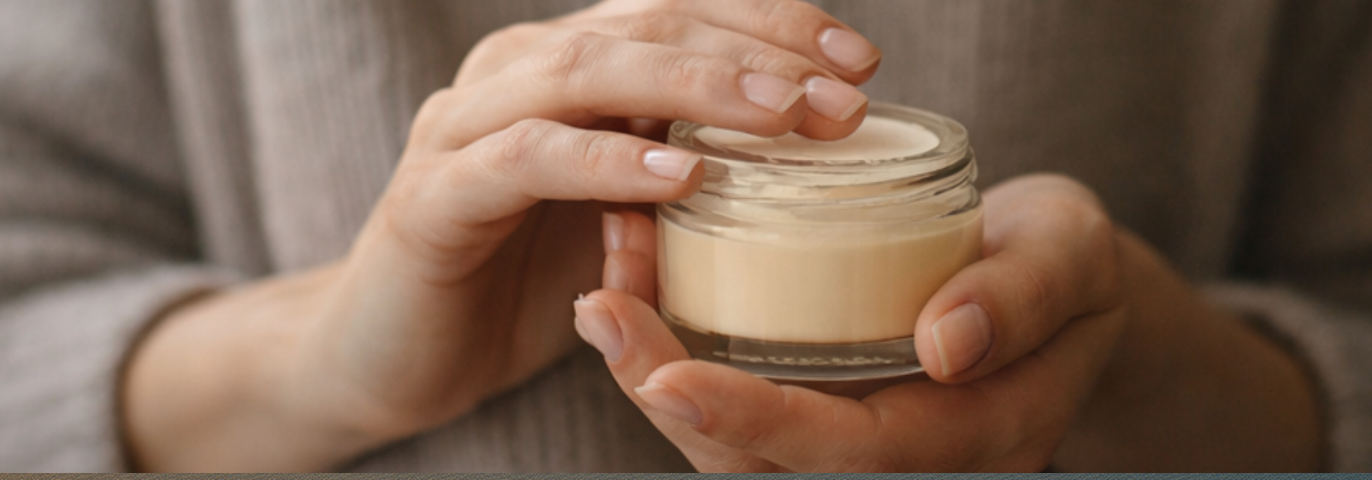 Hands applying thick moisturizer during a winter skincare ritual